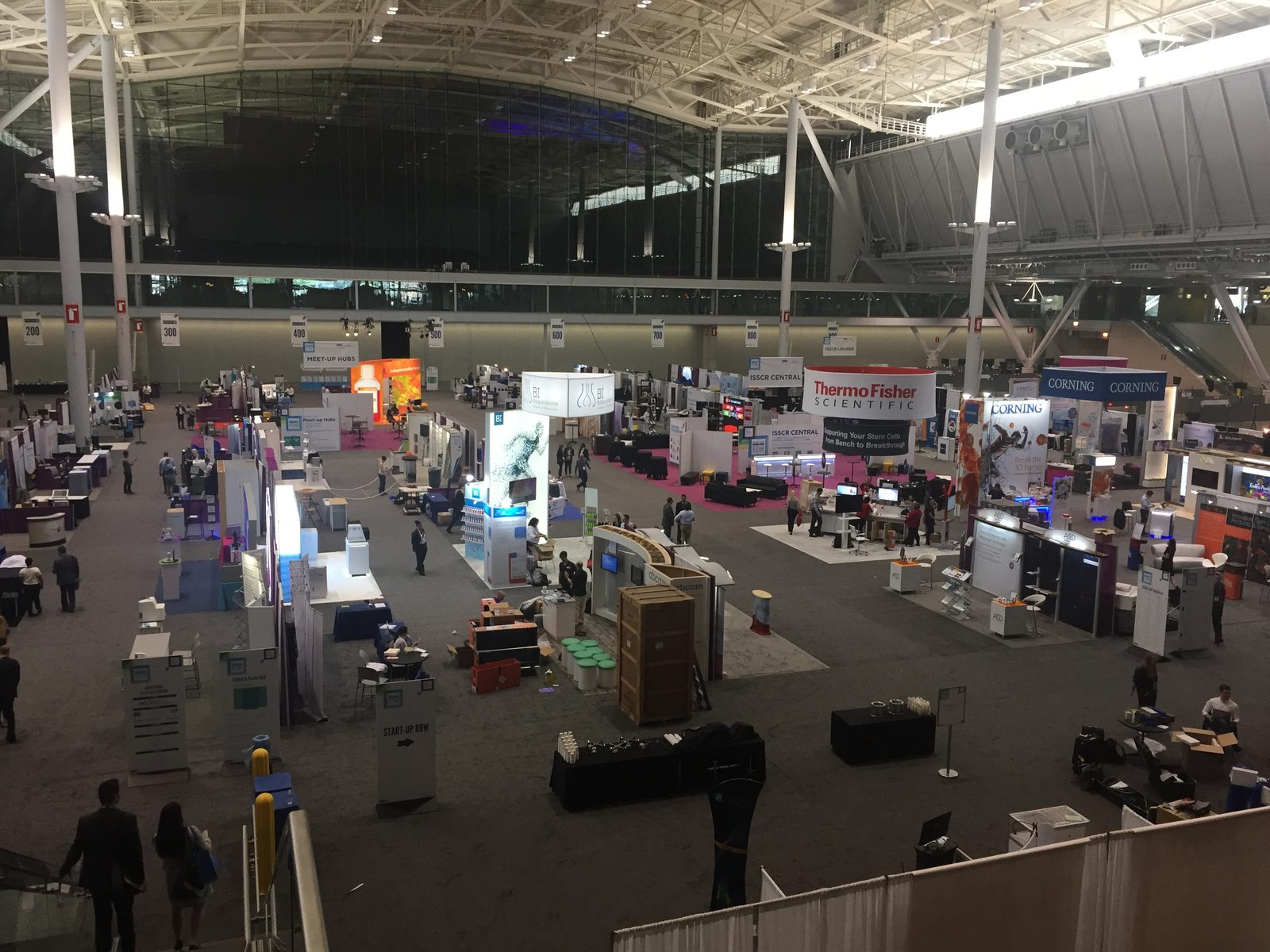 Wide view of a convention hall with exhibits under construction