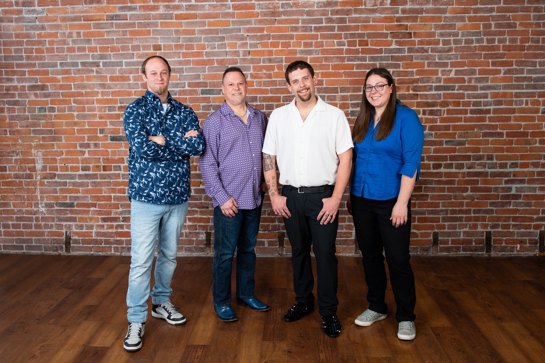 The GEM Exhibits team standing together against a brick wall